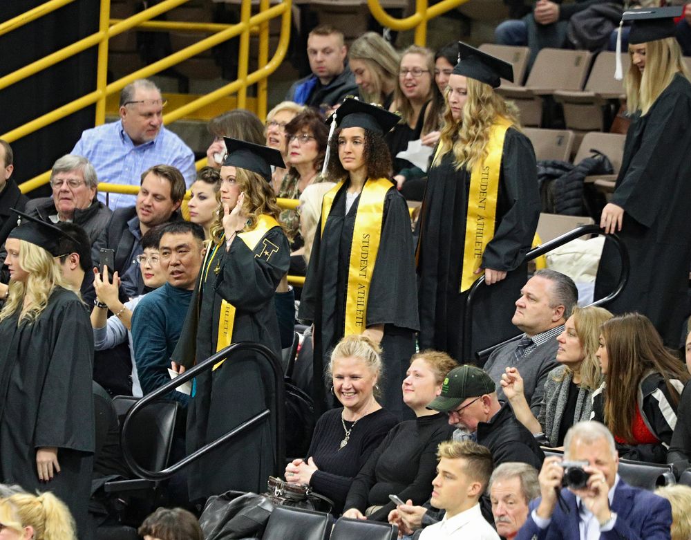Iowa track and field’s Lindsay Welker (from left), Tia Saunders, and Allison Wahrman walk down the steps during the procession in the College of Liberal Arts and Sciences and University College Fall 2019 Commencement ceremony at Carver-Hawkeye Arena in Iowa City on Saturday, December 21, 2019. (Stephen Mally/hawkeyesports.com)
