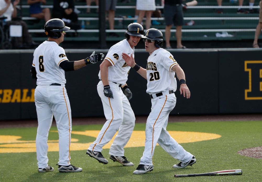 Iowa Hawkeyes catcher Austin Guzzo (20) celebrates with outfielder Luke Farley (8) after scoring against the Oklahoma State Cowboys Saturday, May 5, 2018 at Duane Banks Field. (Brian Ray/hawkeyesports.com)