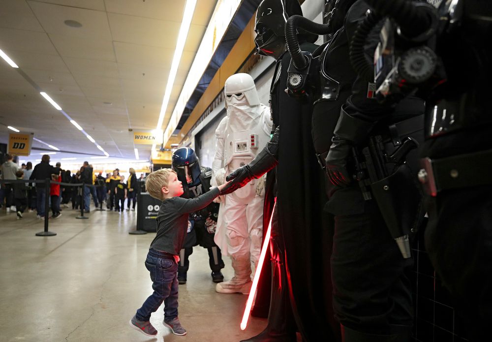 A young Hawkeyes fan gives Darth Vader a high-five on the concourse before the game at Carver-Hawkeye Arena in Iowa City on Sunday, December 29, 2019. (Stephen Mally/hawkeyesports.com)