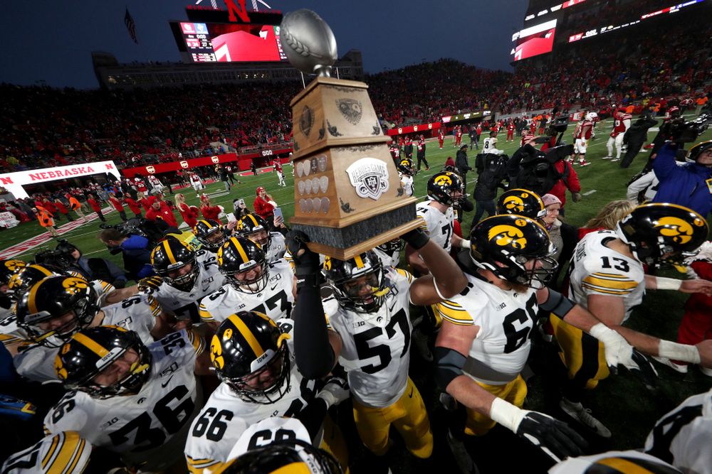 The Iowa Hawkeyes celebrate with the Heroes Game trophy following their win against the Nebraska Cornhuskers Friday, November 29, 2019 at Memorial Stadium in Lincoln, Neb. (Brian Ray/hawkeyesports.com)