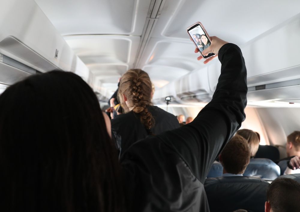 Iowa Hawkeyes forward Megan Gustafson (10) takes selfies with the band and spirit squad on board the team plane to Greensboro, NC for the Regionals of the 2019 NCAA Women's Basketball Championships Thursday, March 28, 2019 at the Eastern Iowa Airport. (Brian Ray/hawkeyesports.com)