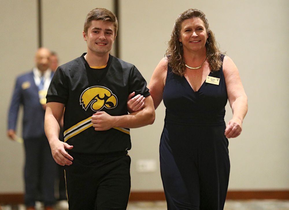 2019 University of Iowa Athletics Hall of Fame inductee Diane Pohl walks to her seat with a Spirit Squad member during the Hall of Fame Induction Ceremony at the Coralville Marriott Hotel and Conference Center in Coralville on Friday, Aug 30, 2019. (Stephen Mally/hawkeyesports.com)