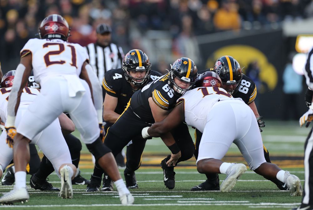 Iowa Hawkeyes offensive lineman Tyler Linderbaum (65) and offensive lineman Landan Paulsen (68) block for quarterback Nate Stanley (4) as he picks up a first down against the Minnesota Golden Gophers Saturday, November 16, 2019 at Kinnick Stadium. (Brian Ray/hawkeyesports.com)