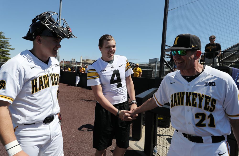 Iowa Hawkeyes quarterback Nate Stanley (4) shakes hands with Iowa Hawkeyes head coach Rick Heller before throwing out a first pitch against the Nebraska Cornhuskers Saturday, April 20, 2019 at Duane Banks Field. (Brian Ray/hawkeyesports.com)