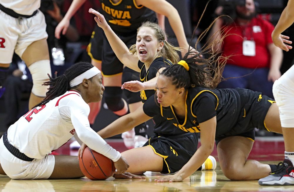 Iowa guard Kathleen Doyle (22) and guard Alexis Sevillian (5) battle for a loose ball during overtime of their game at the Rutgers Athletic Center in Piscataway, N.J. on Sunday, March 1, 2020. (Stephen Mally/hawkeyesports.com)