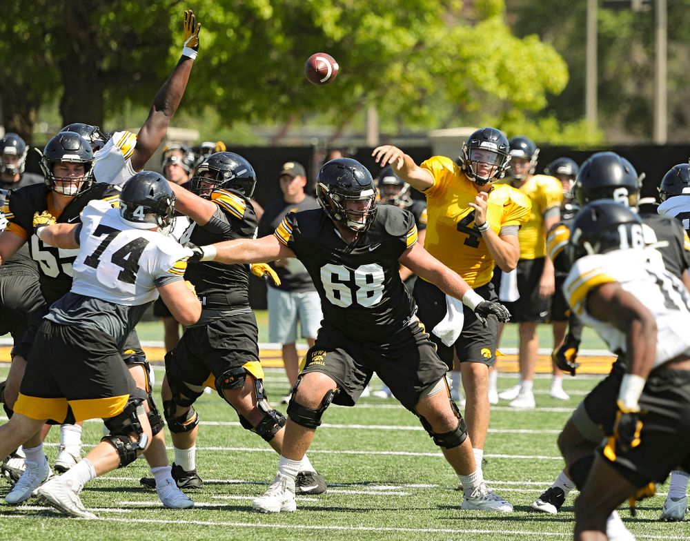 Iowa Hawkeyes quarterback Nate Stanley (4) throws a pass over defensive lineman Austin Schulte (74) and offensive lineman Landan Paulsen (68) during Fall Camp Practice No. 7 at the Hansen Football Performance Center in Iowa City on Friday, Aug 9, 2019. (Stephen Mally/hawkeyesports.com)