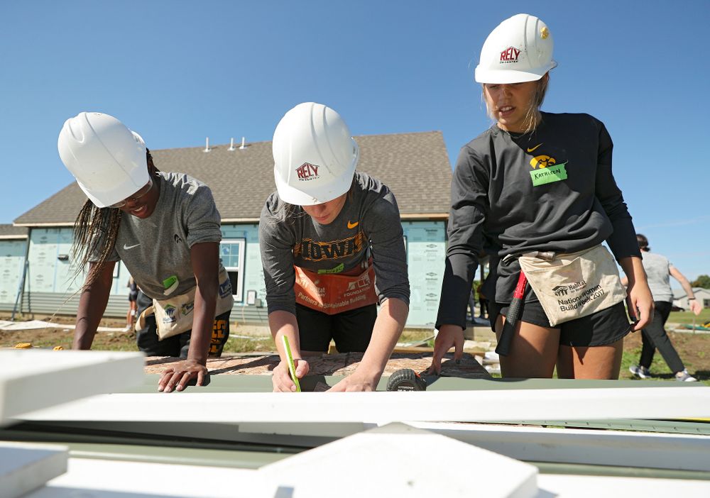 Iowa’s Tomi Taiwo (from left), Kate Martin, and Kathleen Doyle work on cutting a piece of siding as they work on a Habitat for Humanity Women Build project in Iowa City on Wednesday, Sep 25, 2019. (Stephen Mally/hawkeyesports.com)