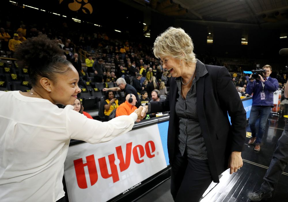 Iowa Hawkeyes head coach Lisa Bluder smiles as she shakes hands with Clemson graduate assistant coach and former Hawkeye Tania Davis before their game Wednesday, December 4, 2019 at Carver-Hawkeye Arena. (Brian Ray/hawkeyesports.com)