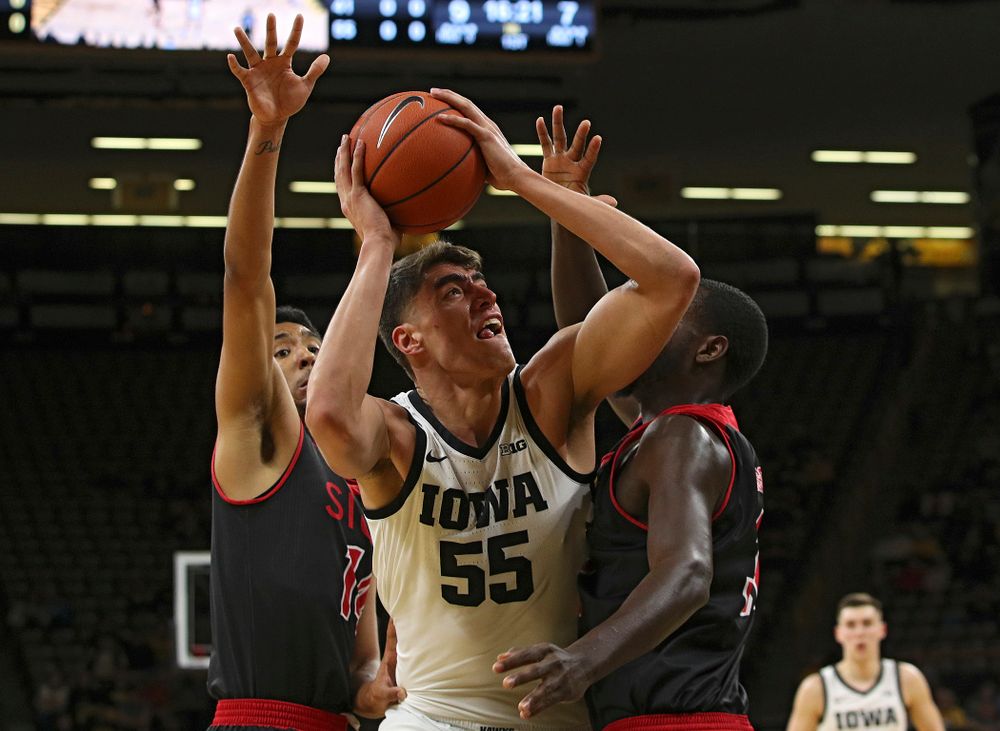 Iowa Hawkeyes center Luka Garza (55) shoots between two defenders during the first half of their game at Carver-Hawkeye Arena in Iowa City on Friday, Nov 8, 2019. (Stephen Mally/hawkeyesports.com)