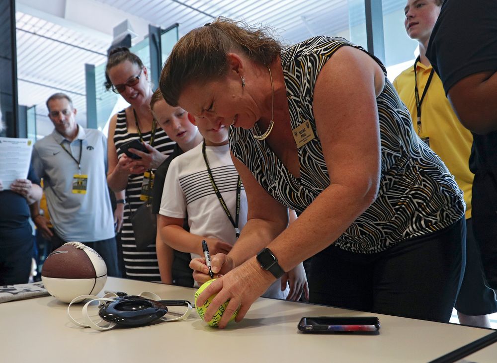 2019 University of Iowa Athletics Hall of Fame inductee Diane Pohl signs a softball at the University of Iowa Athletics Hall of Fame in Iowa City on Friday, Aug 30, 2019. (Stephen Mally/hawkeyesports.com)