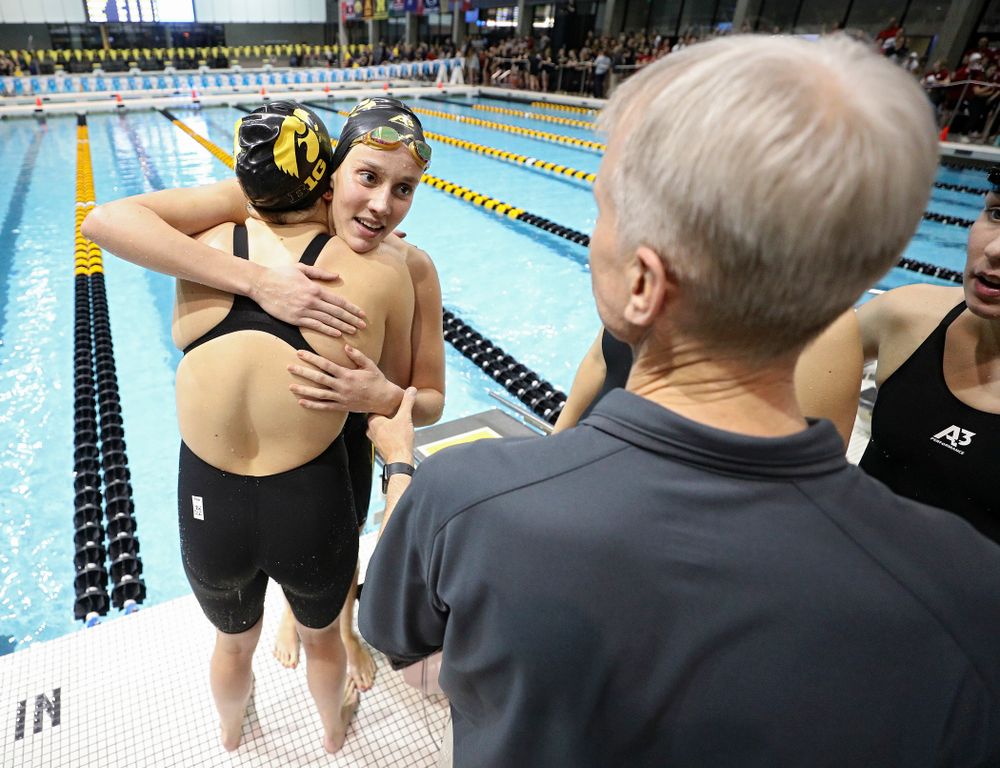 Iowa’s Macy Rink gets a hug as she talks with head coach Marc Long after she swam the 800 yard freestyle relay event during the 2020 Big Ten Women’s Swimming and Diving Championships at the Campus Recreation and Wellness Center in Iowa City on Wednesday, February 19, 2020. (Stephen Mally/hawkeyesports.com)
