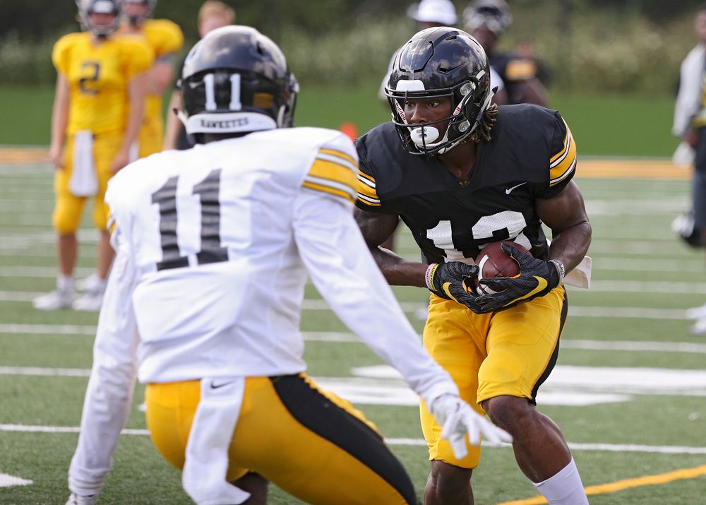 Iowa Hawkeyes wide receiver Brandon Smith (12) tries to avoid defensive back Michael Ojemudia (11) during Fall Camp Practice No. 10 at the Hansen Football Performance Center in Iowa City on Tuesday, Aug 13, 2019. (Stephen Mally/hawkeyesports.com)