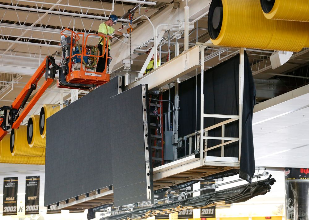 Workers install the video board at the south end of Carver.