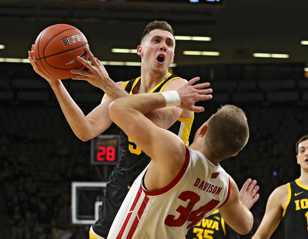 Iowa Hawkeyes guard CJ Fredrick (5) is fouled by Wisconsin Badgers guard Brad Davison (34) as he shoots during the first half of their game at Carver-Hawkeye Arena in Iowa City on Monday, January 27, 2020. (Stephen Mally/hawkeyesports.com)