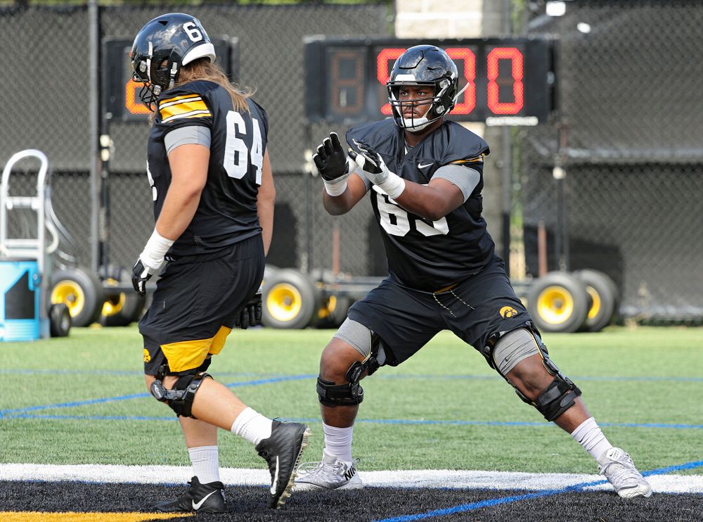 Iowa Hawkeyes offensive lineman Kyler Schott (64) and offensive lineman Justin Britt (63) run a drill during Fall Camp Practice No. 13 at the Hansen Football Performance Center in Iowa City on Friday, Aug 16, 2019. (Stephen Mally/hawkeyesports.com)