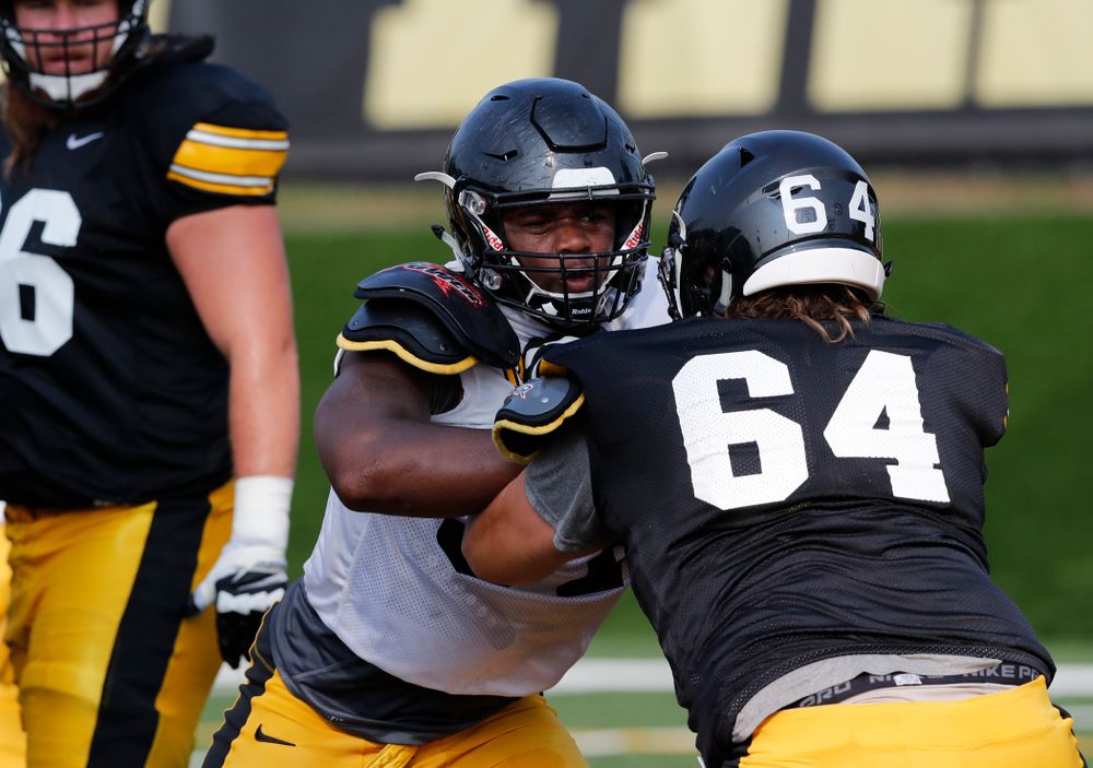 Iowa Hawkeyes defensive end Chauncey Golston (57) and offensive lineman Kyler Schott (64) during camp practice No. 16 Tuesday, August 21, 2018 at the Hansen Football Performance Center. (Brian Ray/hawkeyesports.com)