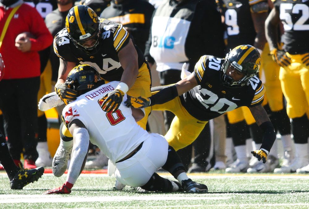 Iowa Hawkeyes defensive end A.J. Epenesa (94) and Iowa Hawkeyes defensive back Julius Brents (20) make a tackle during a game against Maryland at Kinnick Stadium on October 20, 2018. (Tork Mason/hawkeyesports.com)