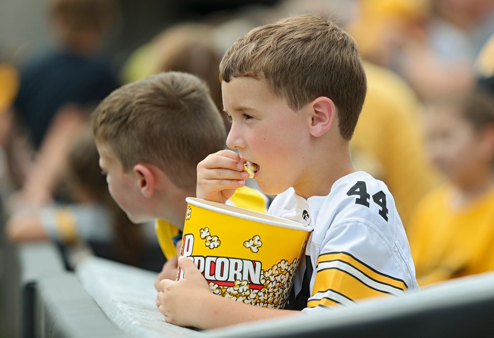 A young fan eats popcorn as he watches Fall Camp Practice No. 8 at Kids Day at Kinnick Stadium in Iowa City on Saturday, Aug 10, 2019. (Stephen Mally/hawkeyesports.com)