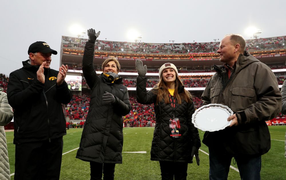 Iowa hero Katie Gudenkauf stands with Iowa Governor Kim Reynolds and Henry B. and Patricia B. Tippie Director of Athletics Chair Gary Barta as she is honored at half-time of the Iowa Hawkeyes game against the Nebraska Cornhuskers Friday, November 29, 2019 at Memorial Stadium in Lincoln, Neb. (Brian Ray/hawkeyesports.com)