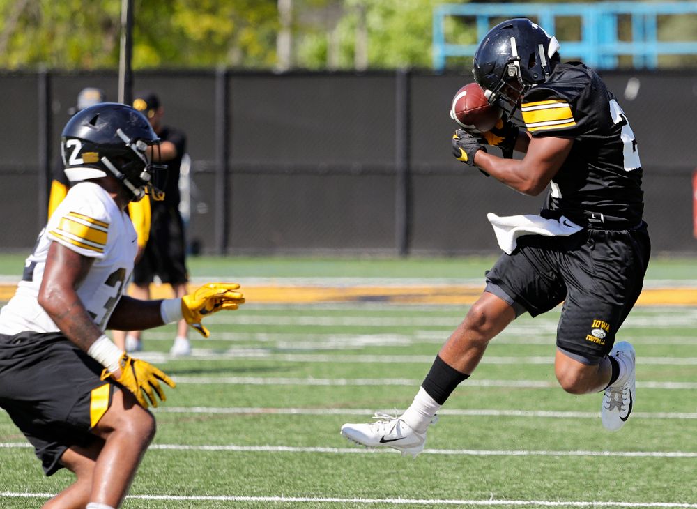 Iowa Hawkeyes running back Ivory Kelly-Martin (21) gathers in a pass against his helmet as linebacker Djimon Colbert (32) closes in during Fall Camp Practice No. 13 at the Hansen Football Performance Center in Iowa City on Friday, Aug 16, 2019. (Stephen Mally/hawkeyesports.com)