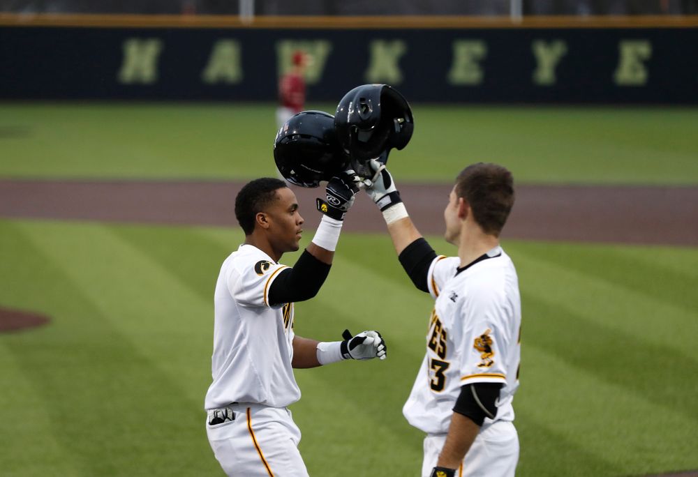 Iowa Hawkeyes third baseman Lorenzo Elion (1) celebrates with Kyle Crowl after hitting a home run against Coe College Wednesday, April 11, 2018 at Duane Banks Field. (Brian Ray/hawkeyesports.com)