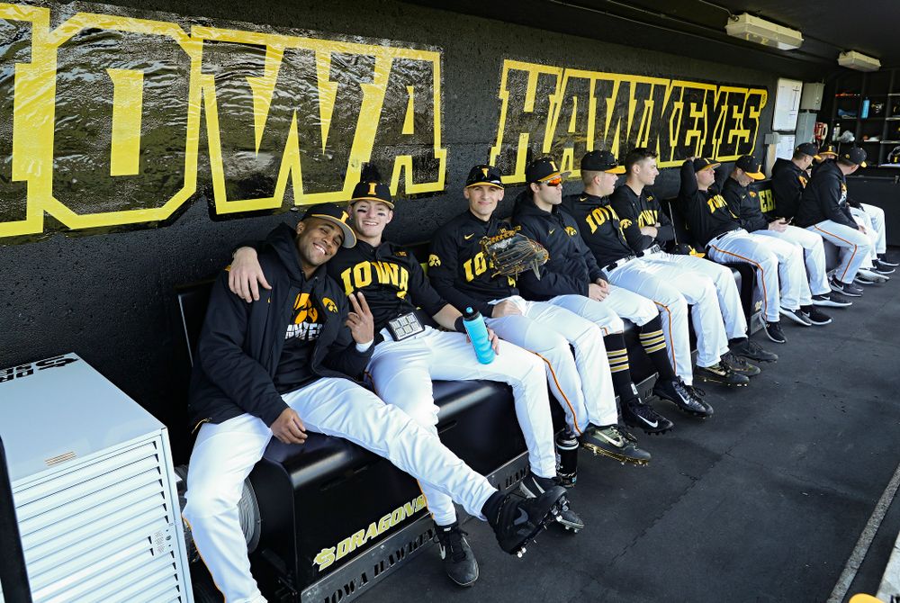 Iowa Hawkeyes players sit on their new Dragon Seats heated benches in the dugout before their game at Duane Banks Field in Iowa City on Tuesday, March 3, 2020. (Stephen Mally/hawkeyesports.com)