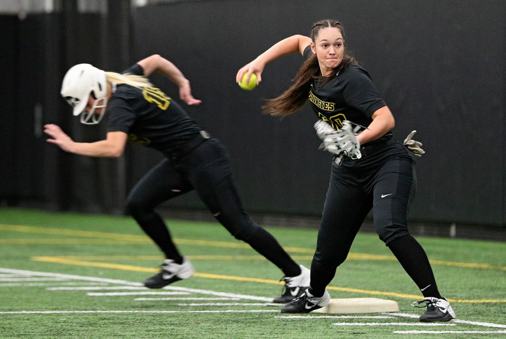 Iowa infielder Kalena Burns (right) throws home while infielder Erin Carter (15) runs to second base as they run a drill during Iowa Softball Media Day at the Hawkeye Tennis and Recreation Complex in Iowa City on Thursday, January 30, 2020. (Stephen Mally/hawkeyesports.com)