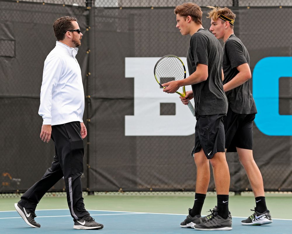 Iowa head coach Ross Wilson (from left) talks with Joe Tyler and Nikita Snezhko during a double match against Ohio State at the Hawkeye Tennis and Recreation Complex in Iowa City on Sunday, Apr. 7, 2019. (Stephen Mally/hawkeyesports.com)