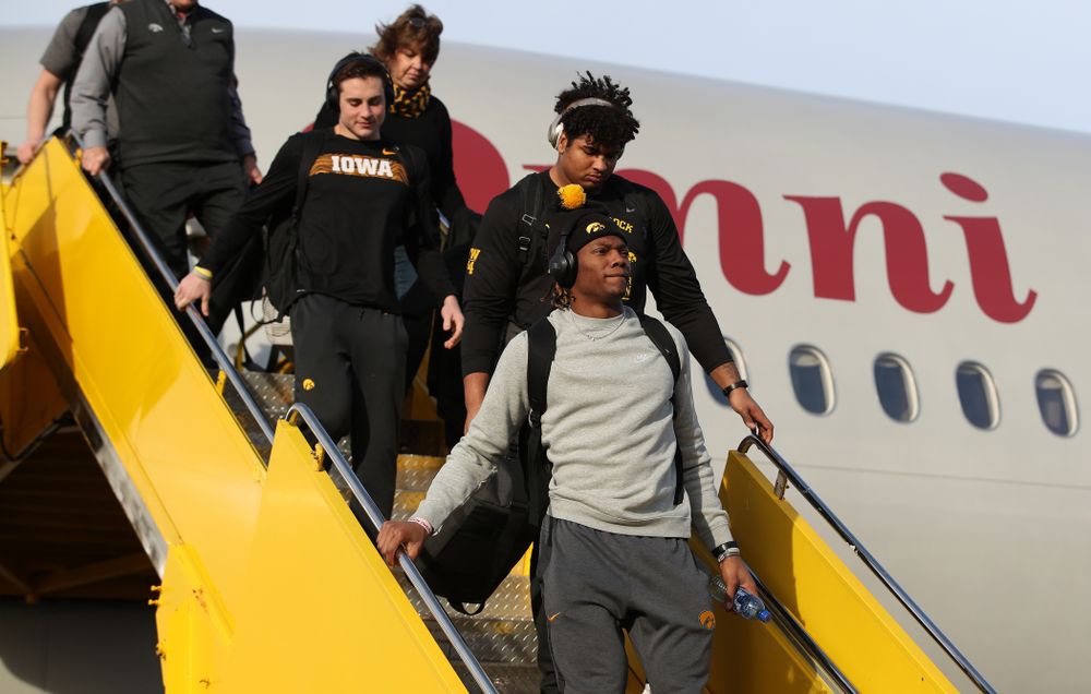 Iowa Hawkeyes wide receiver Brandon Smith (12) and offensive lineman Tristan Wirfs (74) disembark the team plane Wednesday, December 26, 2018 as they arrive in Tampa, Florida for the Outback Bowl. (Brian Ray/hawkeyesports.com)