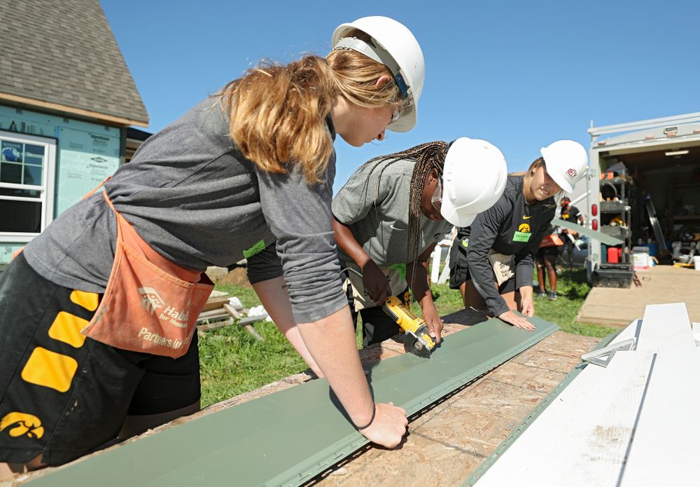 Iowa’s Kate Martin (from left), Tomi Taiwo, and Kathleen Doyle work on cutting a piece of siding as they work on a Habitat for Humanity Women Build project in Iowa City on Wednesday, Sep 25, 2019. (Stephen Mally/hawkeyesports.com)