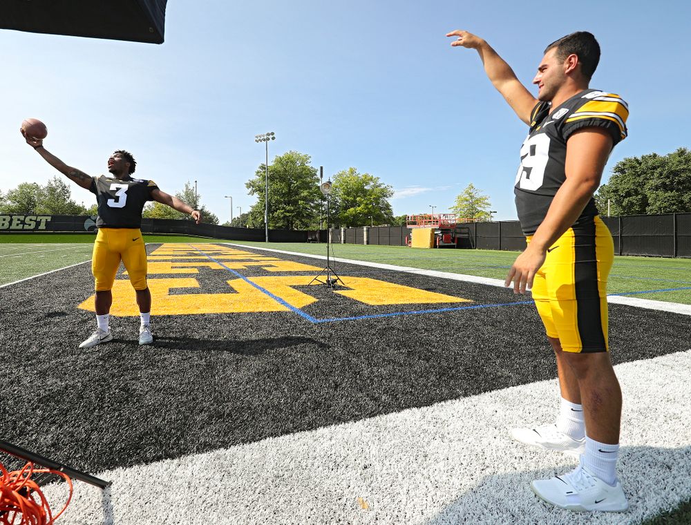 Iowa Hawkeyes wide receiver Nico Ragaini (89) tosses a ball to wide receiver Tyrone Tracy Jr. (3) as a photographer takes pictures during Iowa Football Media Day at the Hansen Football Performance Center in Iowa City on Friday, Aug 9, 2019. (Stephen Mally/hawkeyesports.com)