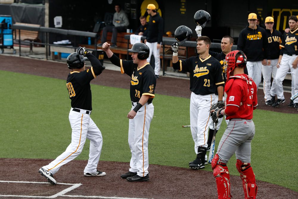 Iowa Hawkeyes catcher Austin Guzzo (20) first bumps infielder Chris Whelan (28) after hitting a home-run against the Bradley Braves Wednesday, March 28, 2018 at Duane Banks Field. (Brian Ray/hawkeyesports.com)