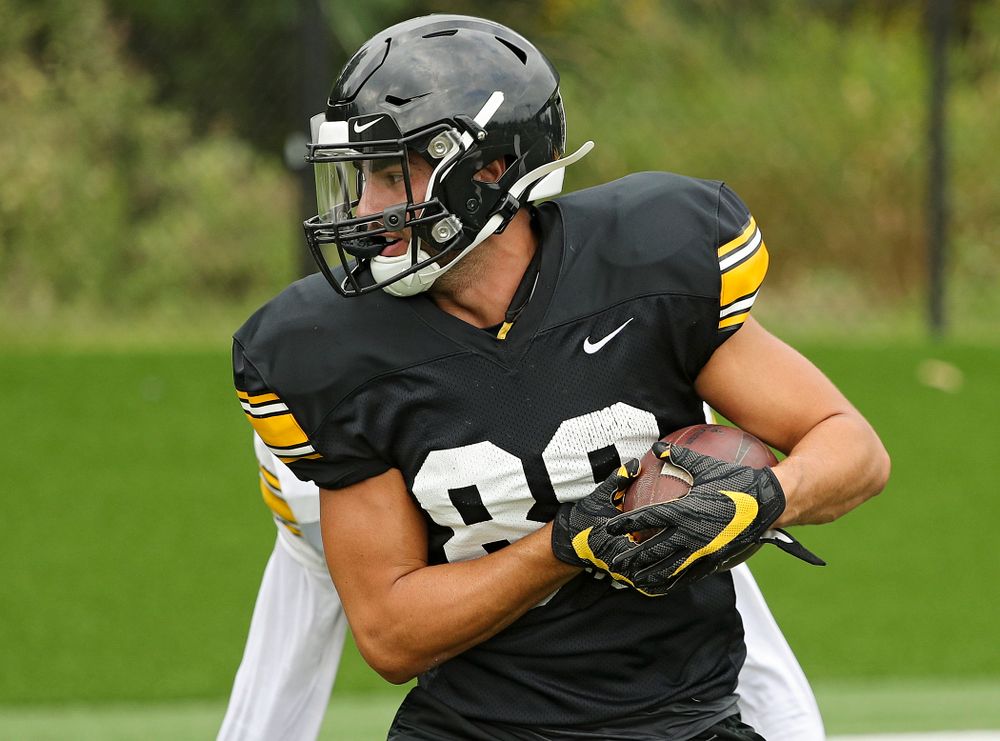 Iowa Hawkeyes wide receiver Nico Ragaini (89) tucks the ball away after pulling in a pass around defensive back Michael Ojemudia (11) during Fall Camp Practice No. 15 at the Hansen Football Performance Center in Iowa City on Monday, Aug 19, 2019. (Stephen Mally/hawkeyesports.com)
