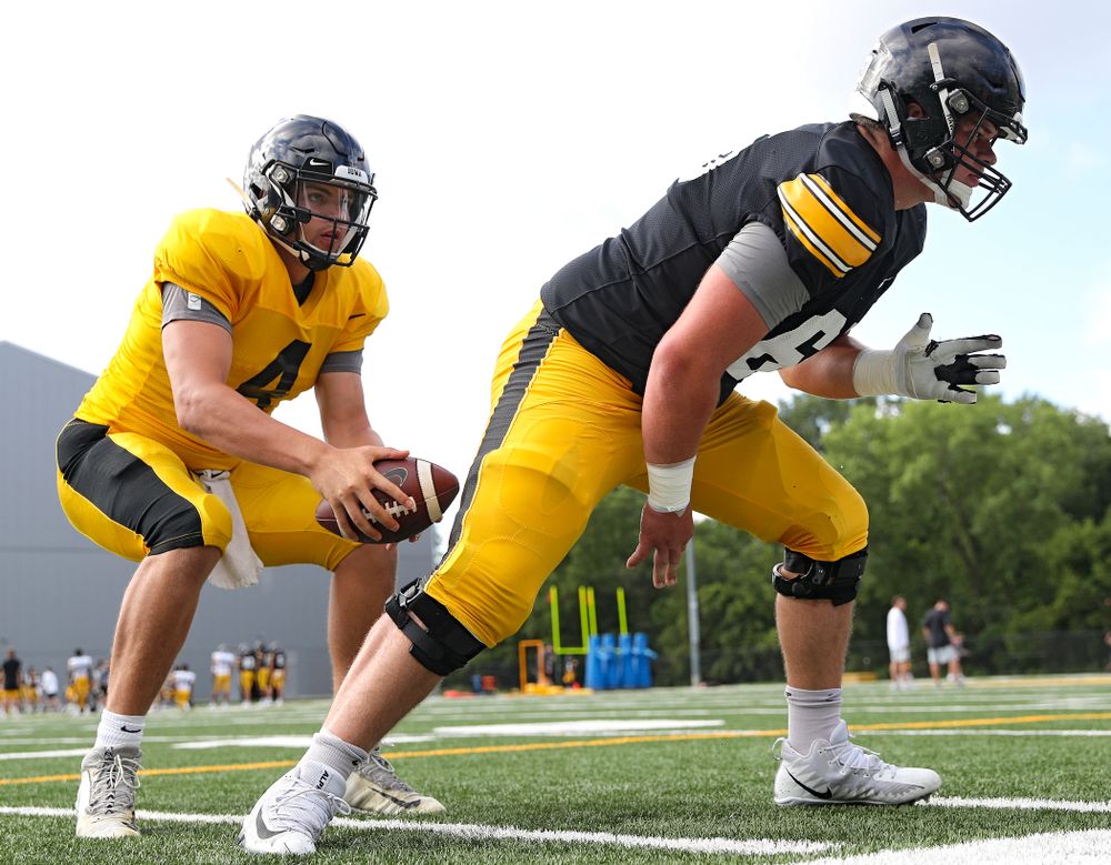 Iowa Hawkeyes quarterback Nate Stanley (4) takes a snap from offensive lineman Tyler Linderbaum (65) during Fall Camp Practice No. 11 at the Hansen Football Performance Center in Iowa City on Wednesday, Aug 14, 2019. (Stephen Mally/hawkeyesports.com)