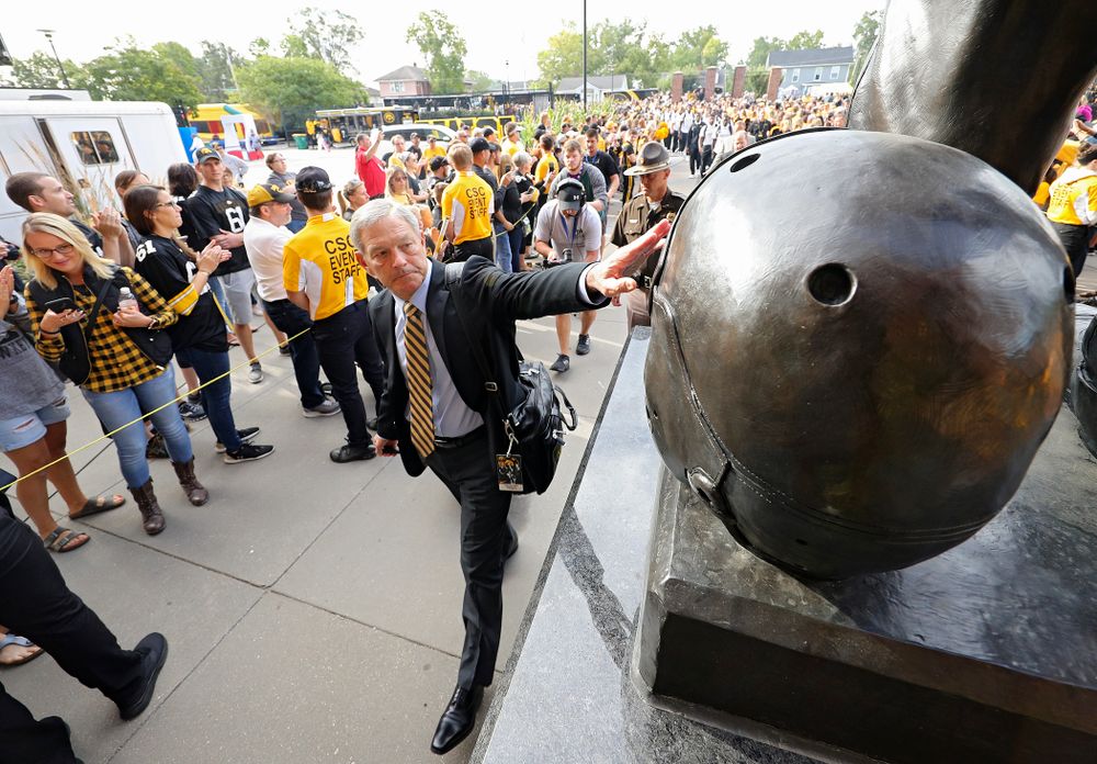 Iowa Hawkeyes head coach Kirk Ferentz touches the helmet on the Nile Kinnick statue as the team arrives before their Big Ten Conference football game at Kinnick Stadium in Iowa City on Saturday, Sep 7, 2019. (Stephen Mally/hawkeyesports.com)