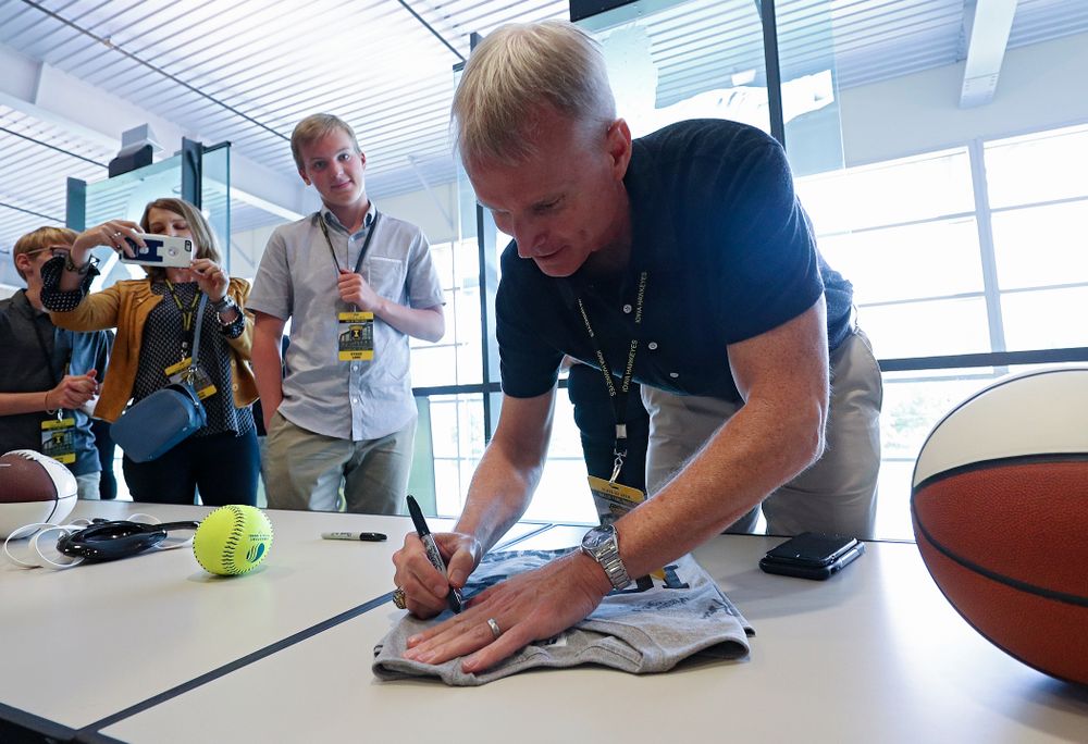 2019 University of Iowa Athletics Hall of Fame inductee and head swimming and diving coach Marc Long signs a shirt at the University of Iowa Athletics Hall of Fame in Iowa City on Friday, Aug 30, 2019. (Stephen Mally/hawkeyesports.com)