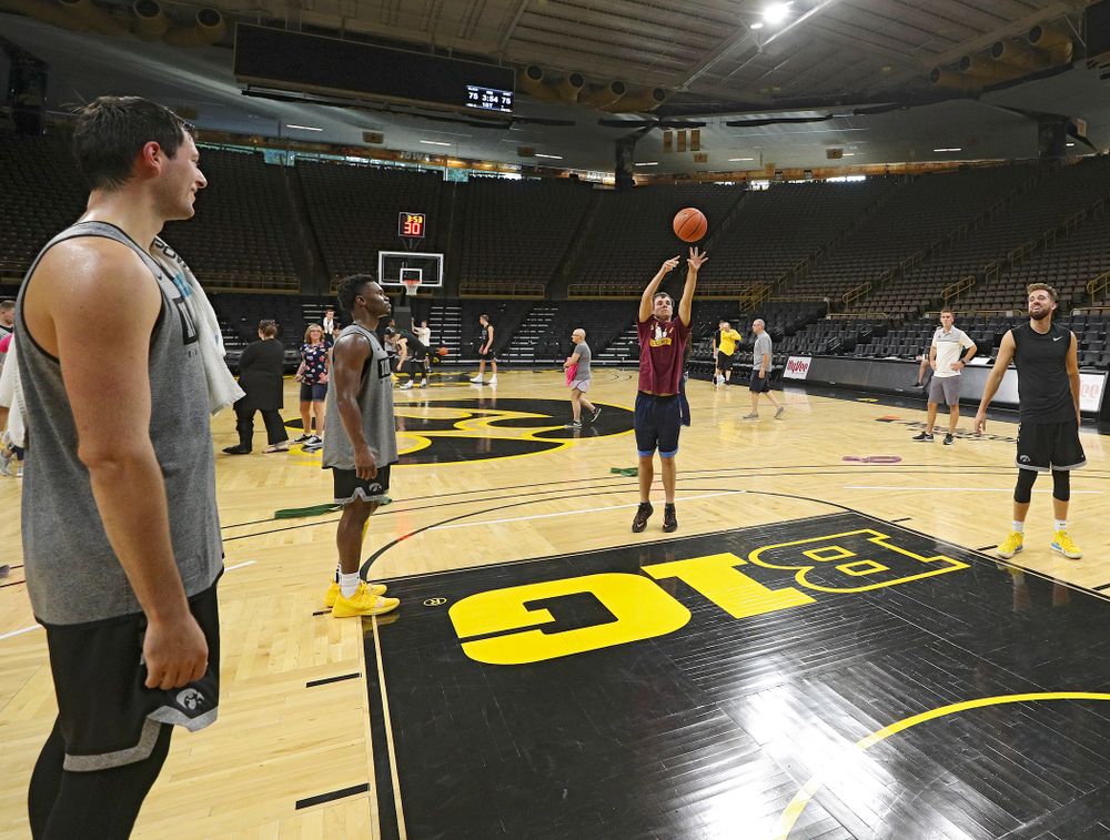 Iowa Hawkeyes forward Ryan Kriener (15), guard Joe Toussaint (1), and guard Jordan Bohannon (3) shoot free throws with visitors from the University of Iowa Hospitals and Clinics Adolescent and Young Adult (AYA) Cancer Program after practice at Carver-Hawkeye Arena in Iowa City on Monday, Sep 30, 2019. (Stephen Mally/hawkeyesports.com)