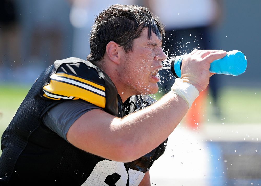Iowa Hawkeyes offensive lineman Tyler Linderbaum (65) sprays water on his face during Fall Camp Practice #5 at the Hansen Football Performance Center in Iowa City on Tuesday, Aug 6, 2019. (Stephen Mally/hawkeyesports.com)