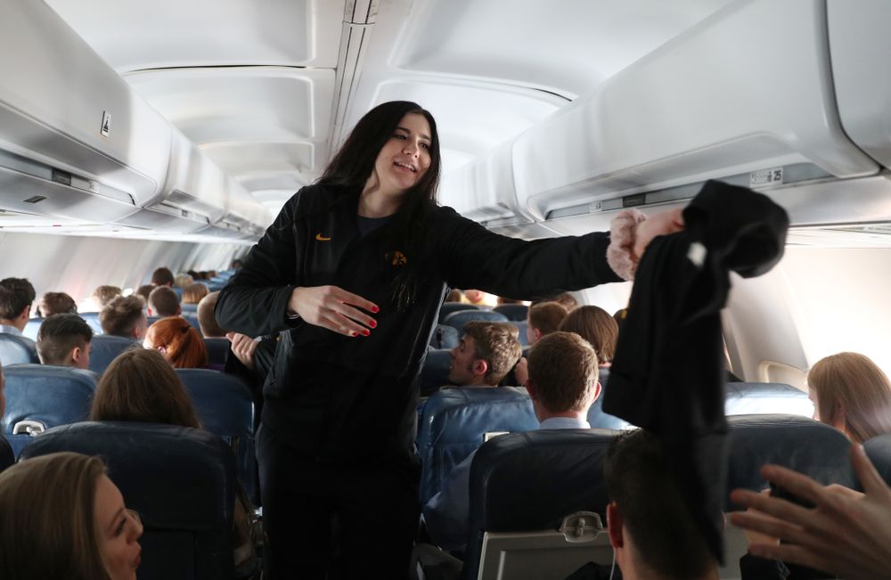 Iowa Hawkeyes forward Megan Gustafson (10) hands out t-shirts to the band and spirit squad on board the team plane to Greensboro, NC for the Regionals of the 2019 NCAA Women's Basketball Championships Thursday, March 28, 2019 at the Eastern Iowa Airport. (Brian Ray/hawkeyesports.com)