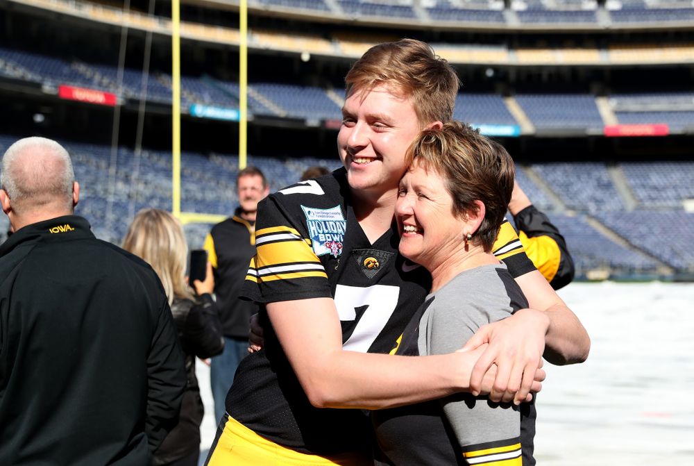 Iowa Hawkeyes quarterback Spencer Petras (7) hugs his mother following the team photo Wednesday, December 25, 2019 at SDCCU Stadium in San Diego. (Brian Ray/hawkeyesports.com)