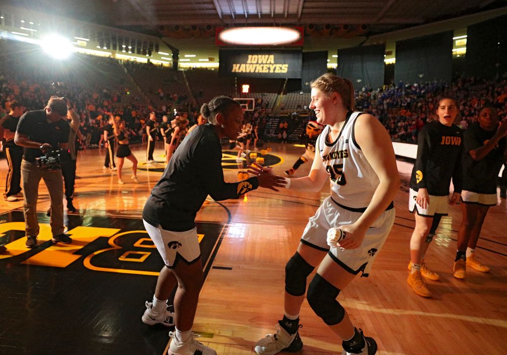 Iowa Hawkeyes guard Zion Sanders (21) shakes hands with forward Monika Czinano (25) as she is introduced before their game at Carver-Hawkeye Arena in Iowa City on Saturday, December 21, 2019. (Stephen Mally/hawkeyesports.com)