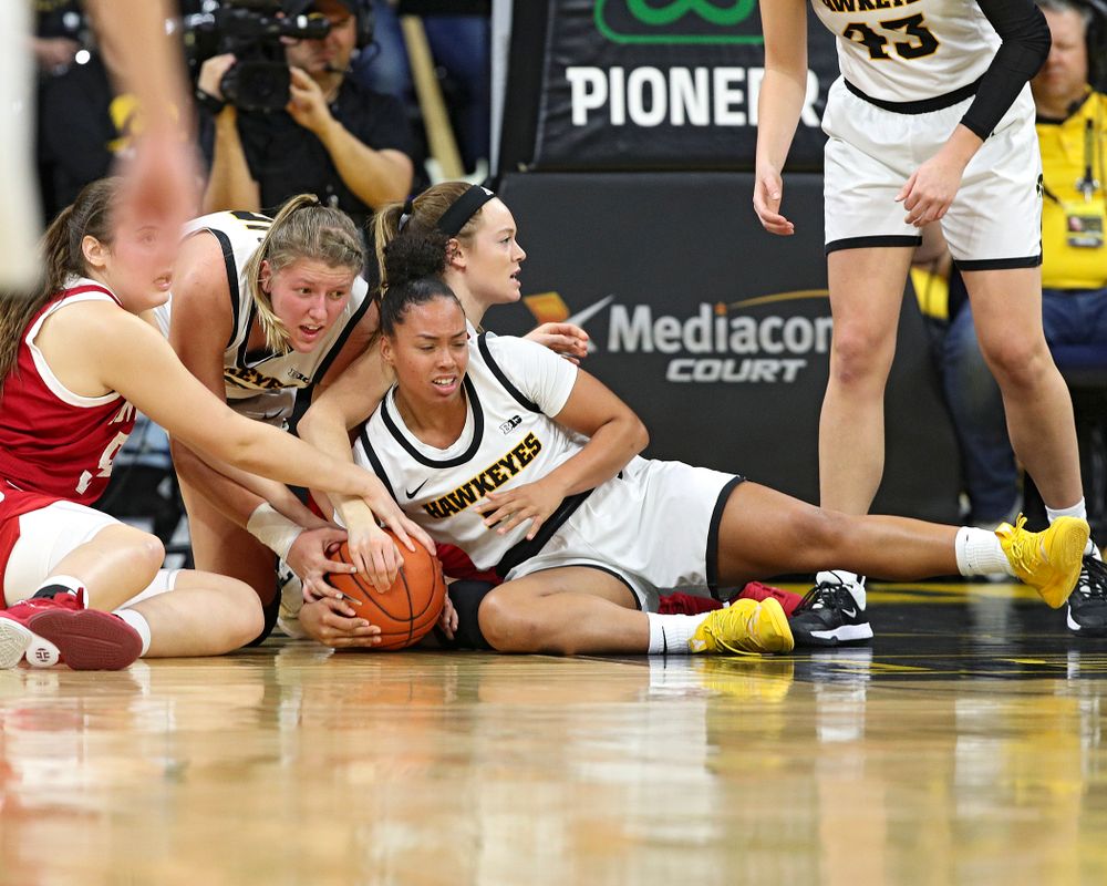Iowa Hawkeyes forward Monika Czinano (25) and guard Alexis Sevillian (5) keep their hands on a held ball during the third quarter of their game at Carver-Hawkeye Arena in Iowa City on Sunday, January 12, 2020. (Stephen Mally/hawkeyesports.com)
