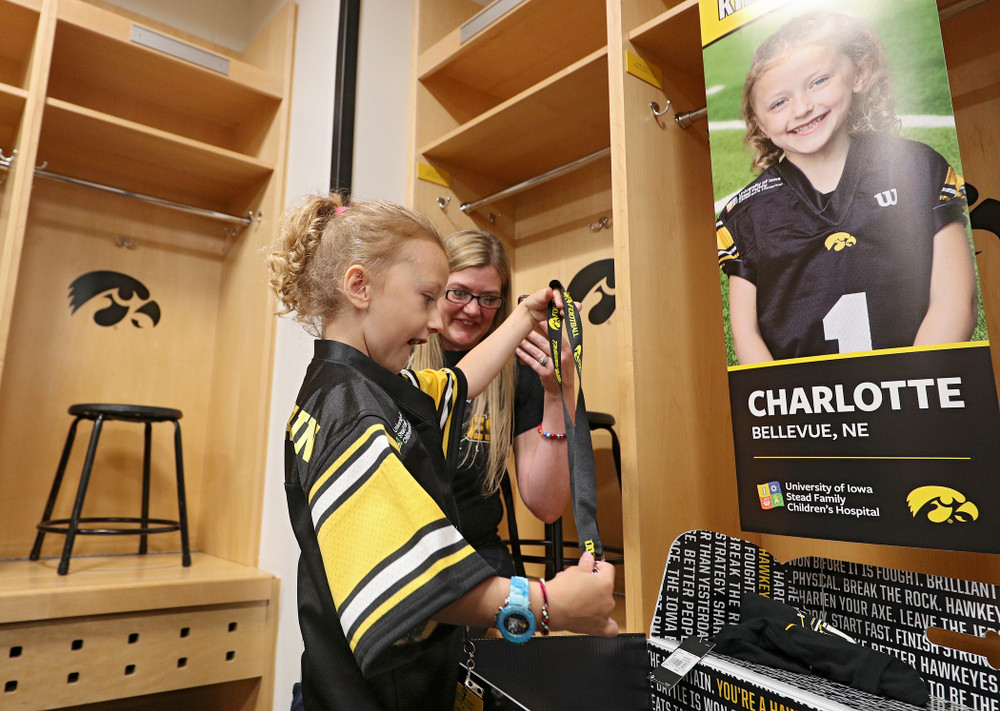 Kid Captain Charlotte Keller opens her box of gifts at her locker during Kids Day at Kinnick Stadium in Iowa City on Saturday, Aug 10, 2019. (Stephen Mally/hawkeyesports.com)