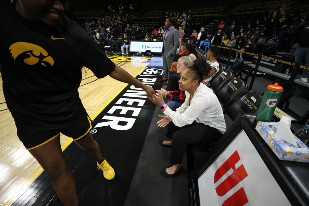 Former Hawkeye and Clemson graduate assistant Tania Davis slaps hands with Iowa Hawkeyes guard Alexis Sevillian (5) before their game Wednesday, December 4, 2019 at Carver-Hawkeye Arena. (Brian Ray/hawkeyesports.com)