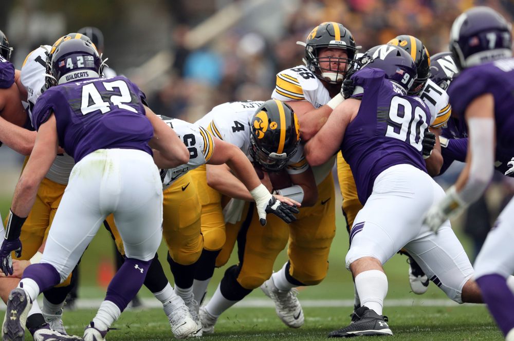 Iowa Hawkeyes quarterback Nate Stanley (4) picks up a first down against the Northwestern Wildcats Saturday, October 26, 2019 at Ryan Field in Evanston, Ill. (Brian Ray/hawkeyesports.com)