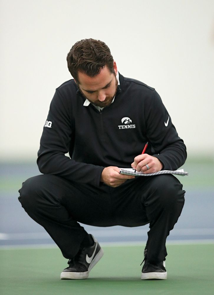 Iowa head coach Ross Wilson takes notes during their match at the Hawkeye Tennis and Recreation Complex in Iowa City on Thursday, January 16, 2020. (Stephen Mally/hawkeyesports.com)