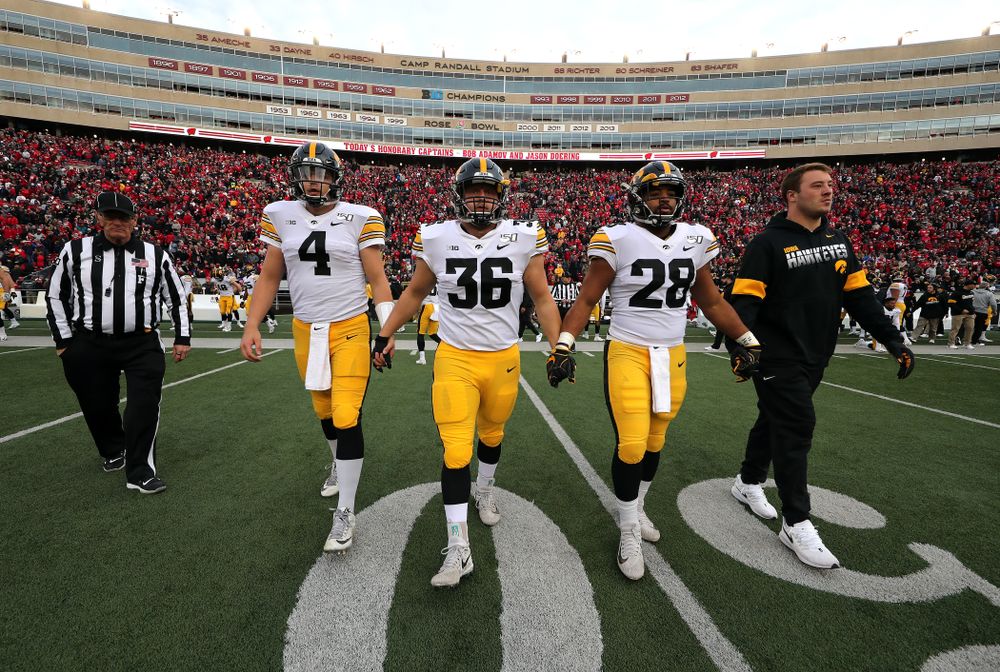 Iowa Hawkeyes captains quarterback Nate Stanley (4), fullback Brady Ross (36), running back Toren Young (28), and linebacker Kristian Welch (34) walk out for the coin toss against the Wisconsin Badgers Saturday, November 9, 2019 at Camp Randall Stadium in Madison, Wisc. (Brian Ray/hawkeyesports.com)