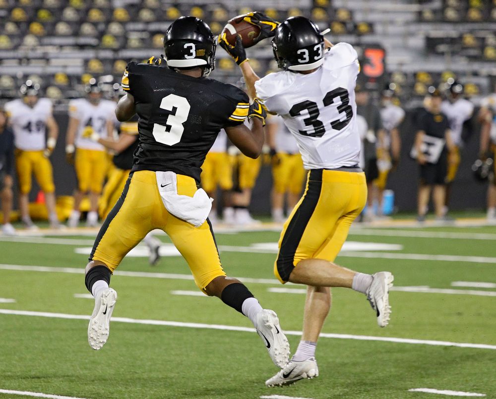 Iowa Hawkeyes defensive back Riley Moss (33) intercepts a pass intended for wide receiver Tyrone Tracy Jr. (3) during Fall Camp Practice No. 12 at Kinnick Stadium in Iowa City on Thursday, Aug 15, 2019. (Stephen Mally/hawkeyesports.com)