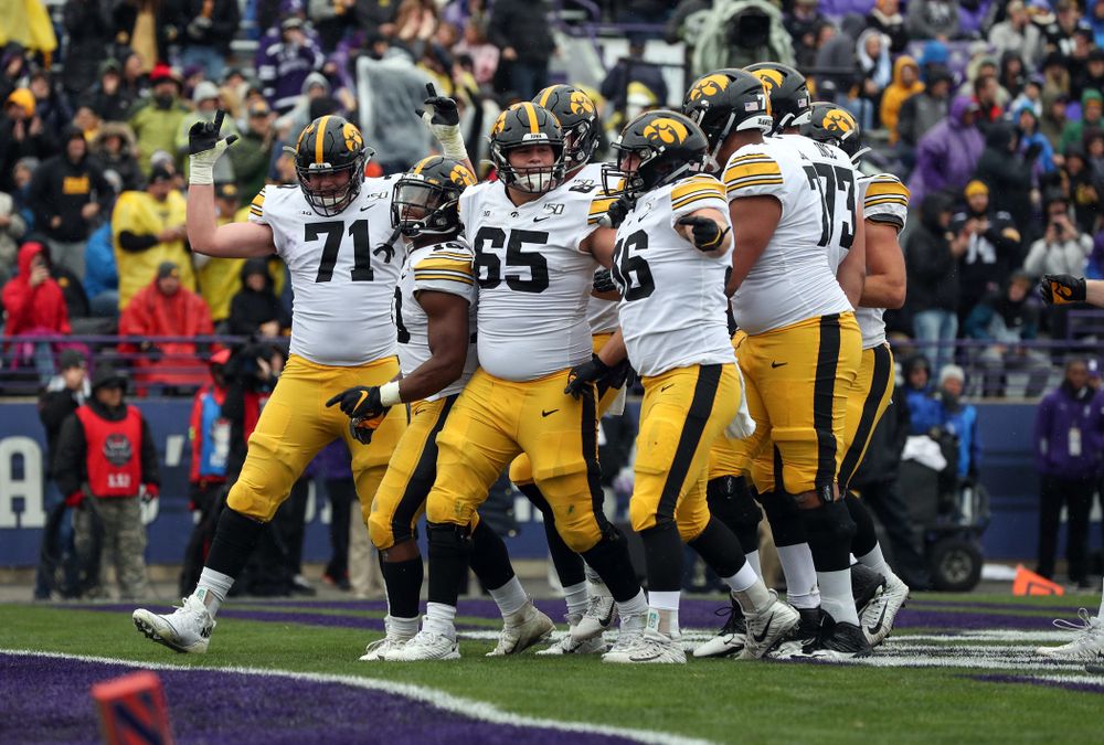 Iowa Hawkeyes offensive lineman Mark Kallenberger (71), running back Mekhi Sargent (10), offensive lineman Tyler Linderbaum (65), and fullback Brady Ross (36) celebrate a touchdown against the Northwestern Wildcats Saturday, October 26, 2019 at Ryan Field in Evanston, Ill. (Brian Ray/hawkeyesports.com)