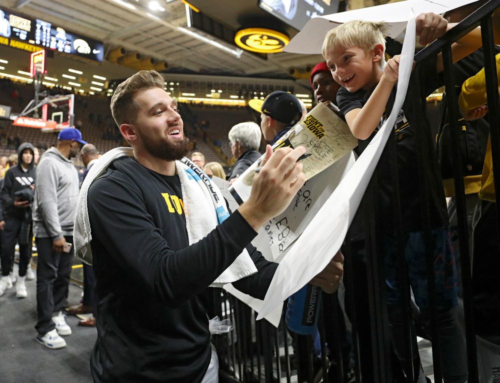 Iowa Hawkeyes guard Jordan Bohannon (3) autographs a poster for a young fan after winning their game at Carver-Hawkeye Arena in Iowa City on Friday, Nov 8, 2019. (Stephen Mally/hawkeyesports.com)